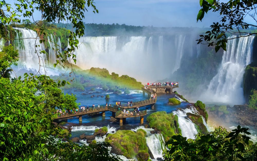 Iguazu Falls with a rainbow over the walkway