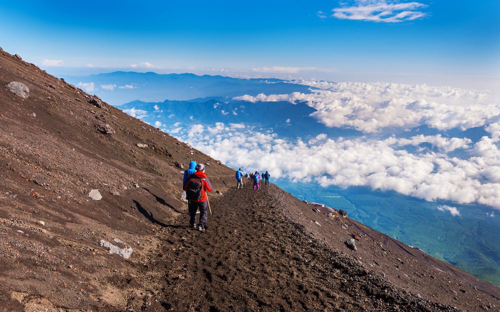 Hikers climbing Mount Fuji above the clouds