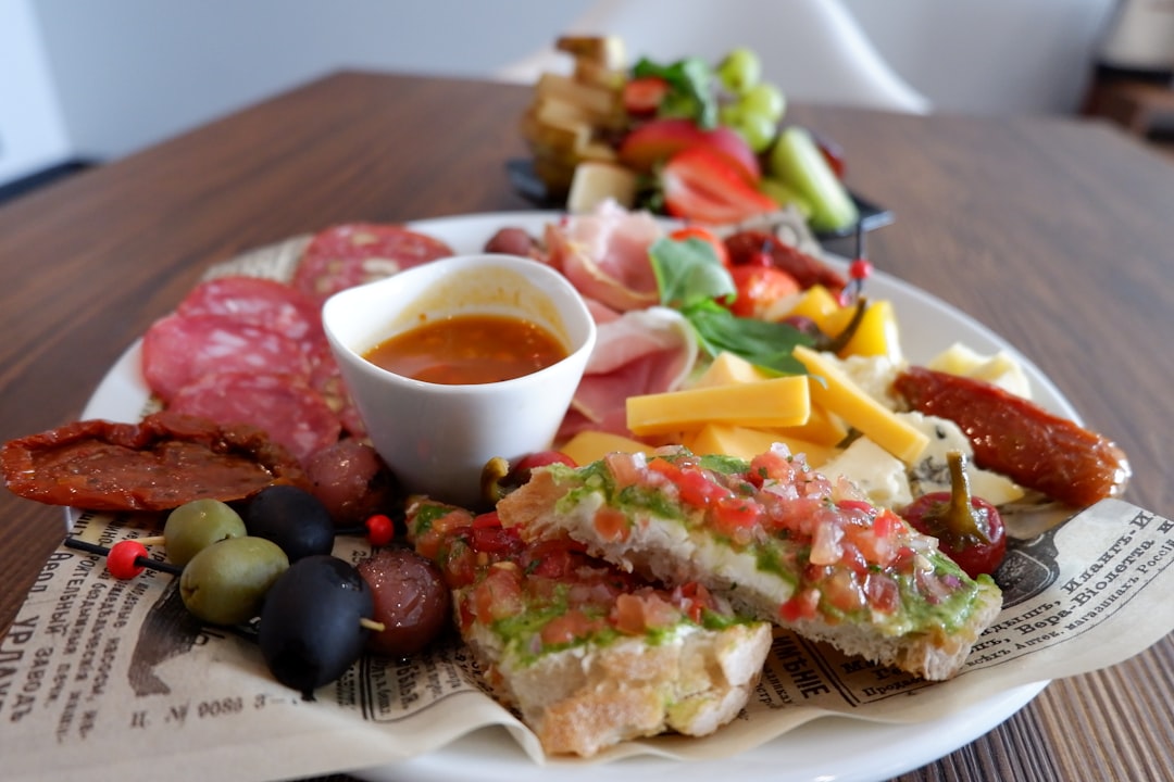 Plates of Spanish tapas including jamon and patatas bravas on a wooden bar